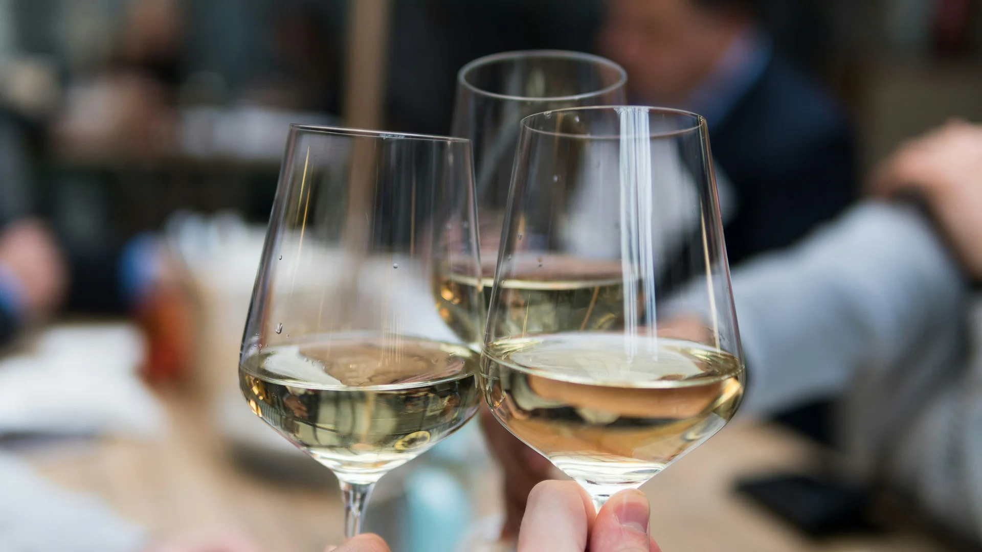 Winery in South Tyrol: indulgence at Hotel Plattenhof Three glasses of white wine clinking together in a social setting