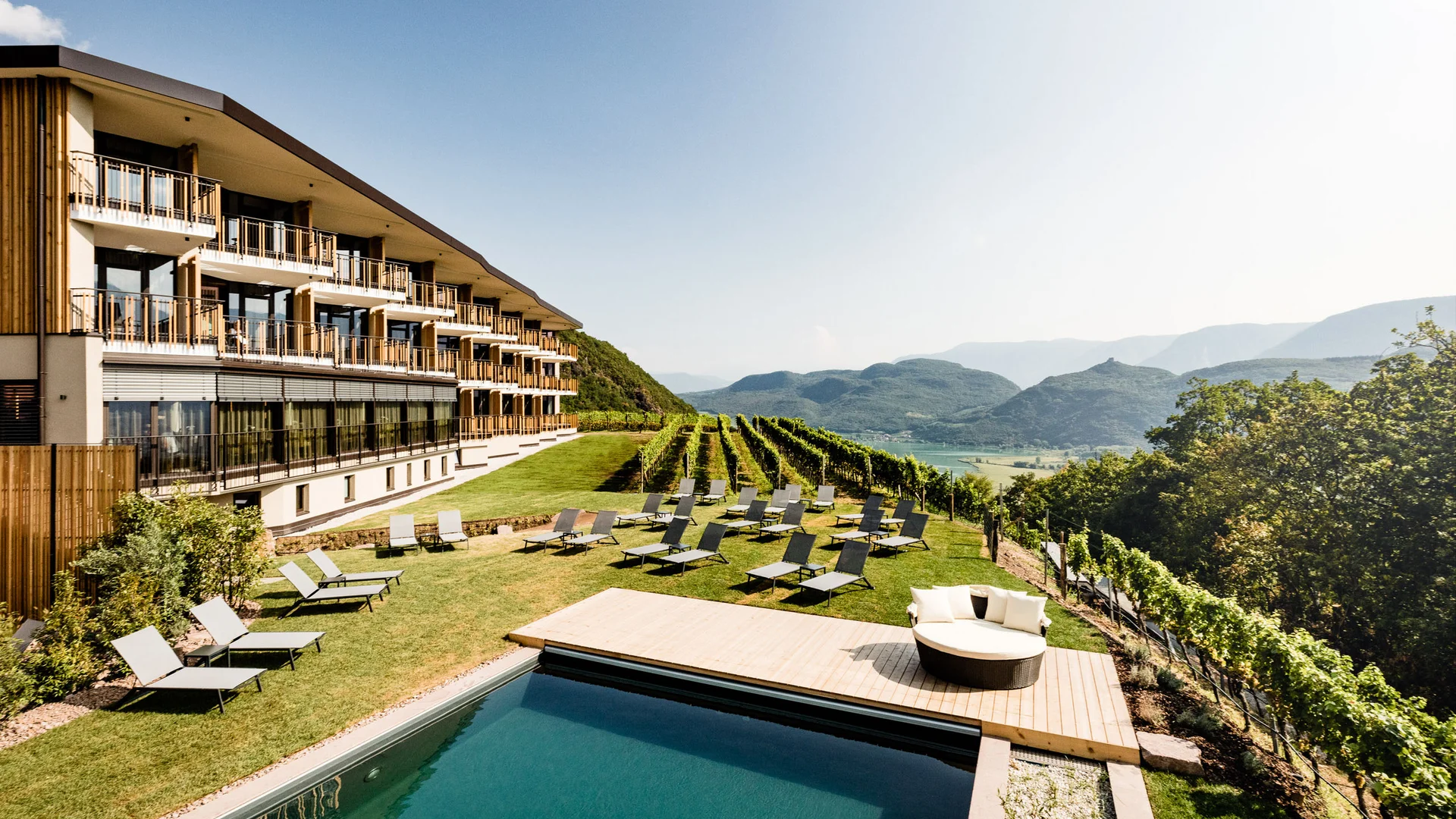 Hotel Plattenhof: your home amongst the vineyards Hotel with pool, sun loungers and vineyards set against a mountain backdrop in the sunshine