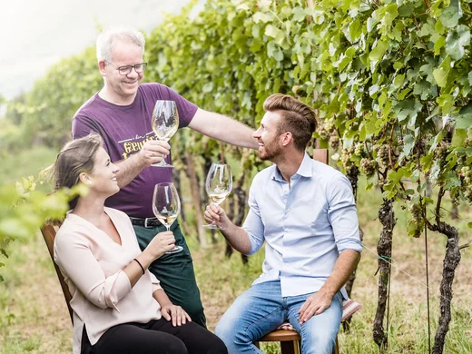 Winery in South Tyrol: indulgence at Hotel Plattenhof Three people drinking wine in a vineyard