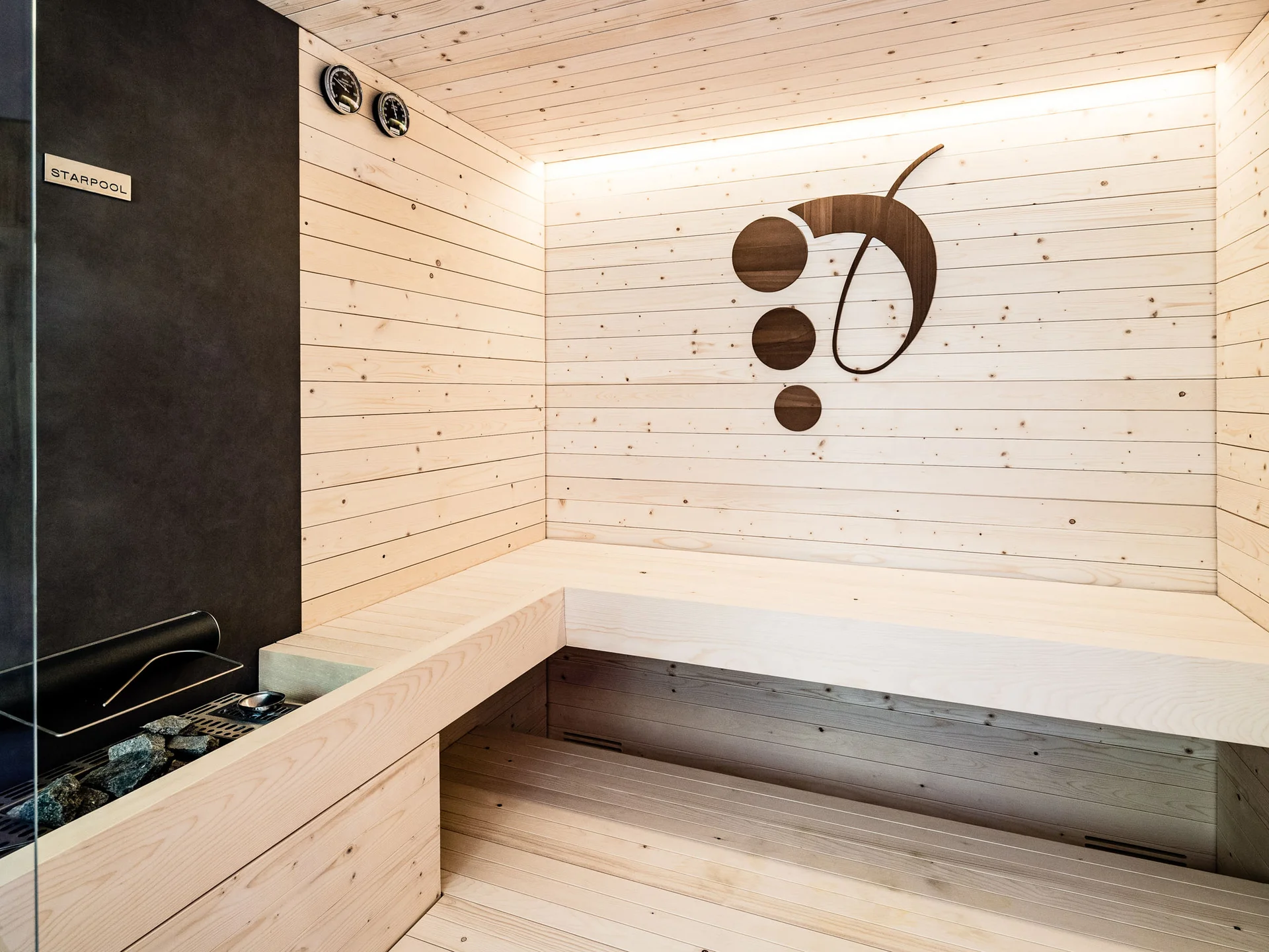 Modern sauna room with light wood paneling and decorative wall design